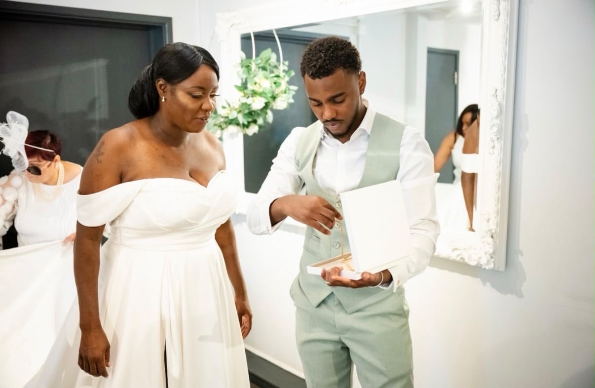 Joshua Vanderpool presenting a finished necklace in its box to a bride